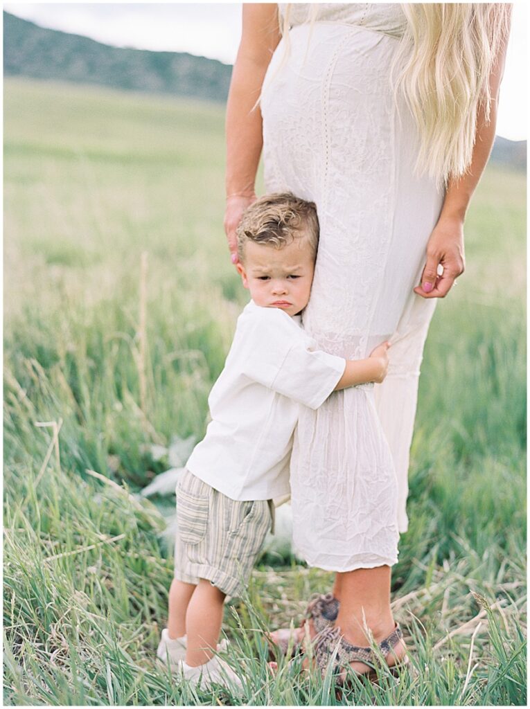 Little boy hugging Mother in field on path 