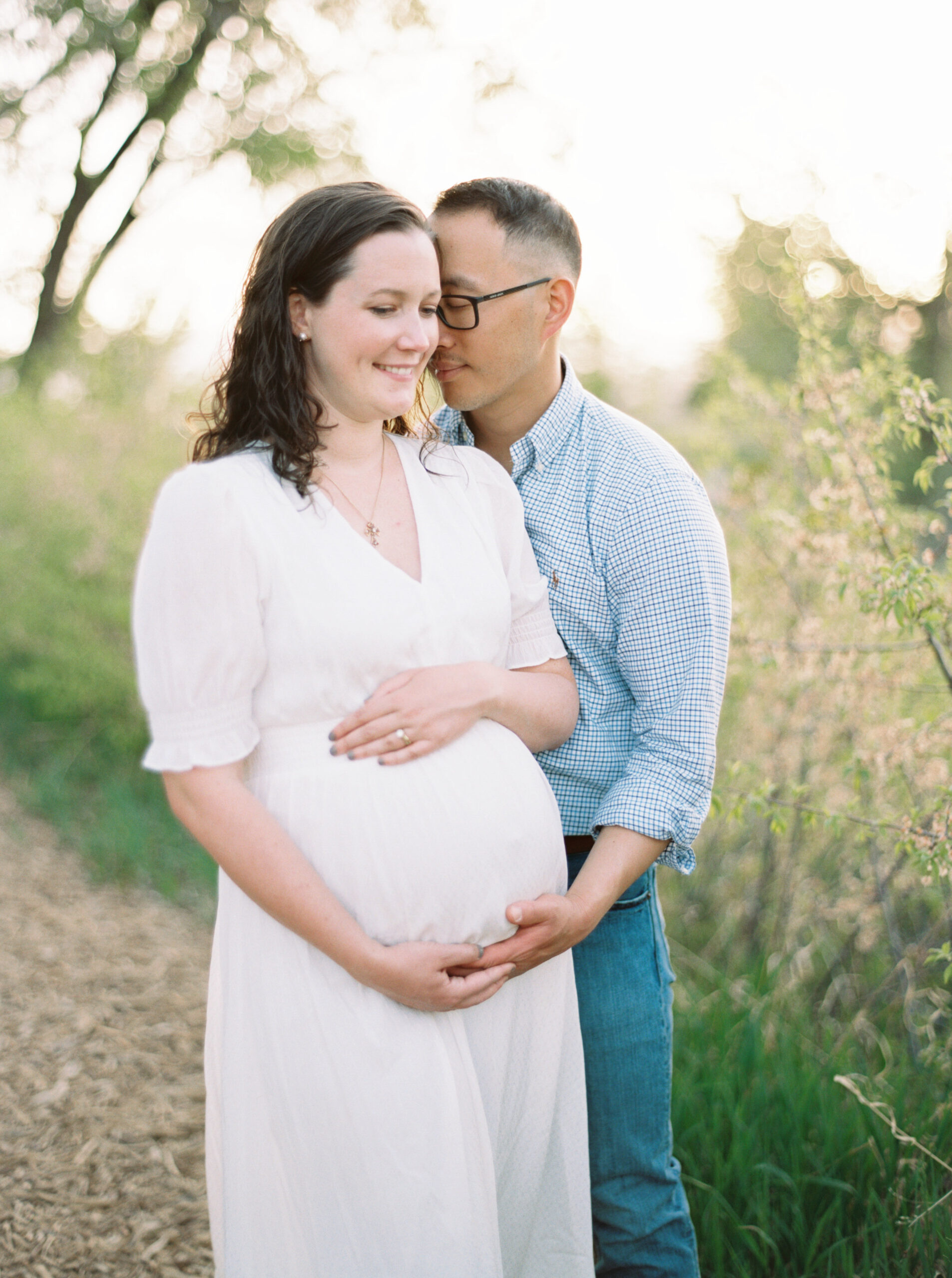 pregnant mother and husband smile during their denver maternity session