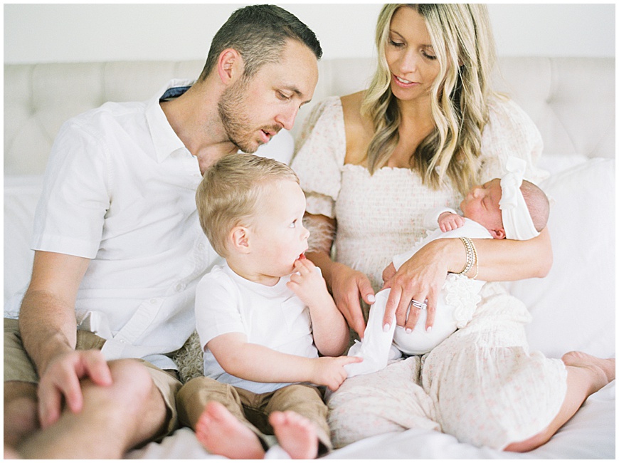 family of four on bed during denver newborn session