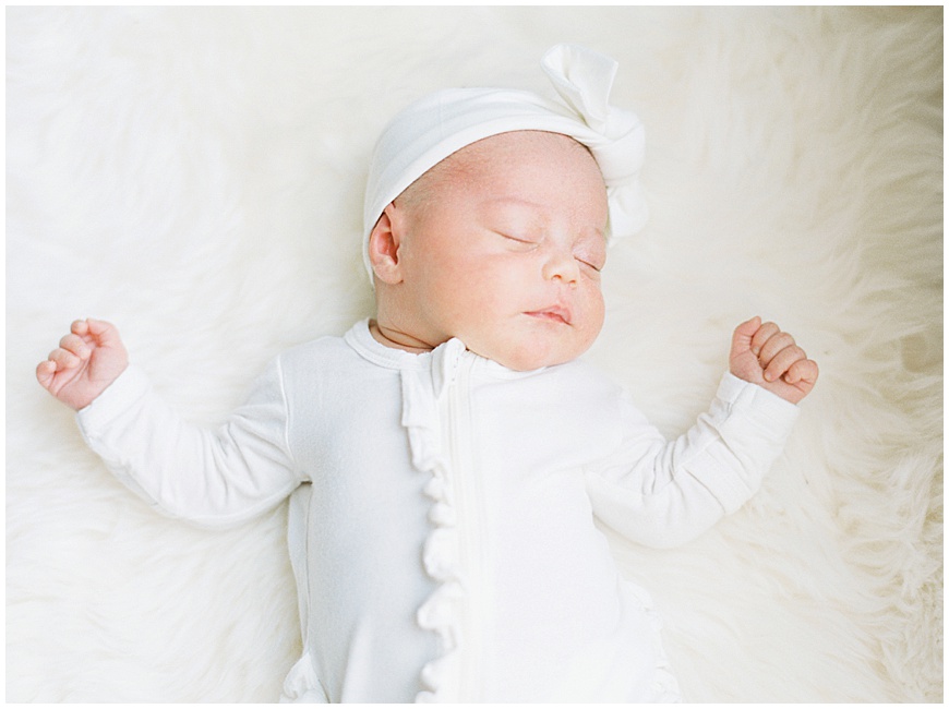 newborn baby in white with white bow