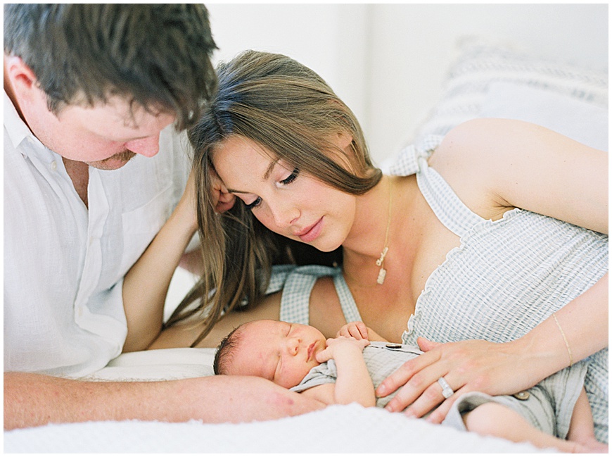 Newborn baby and mother on bed during newborn session