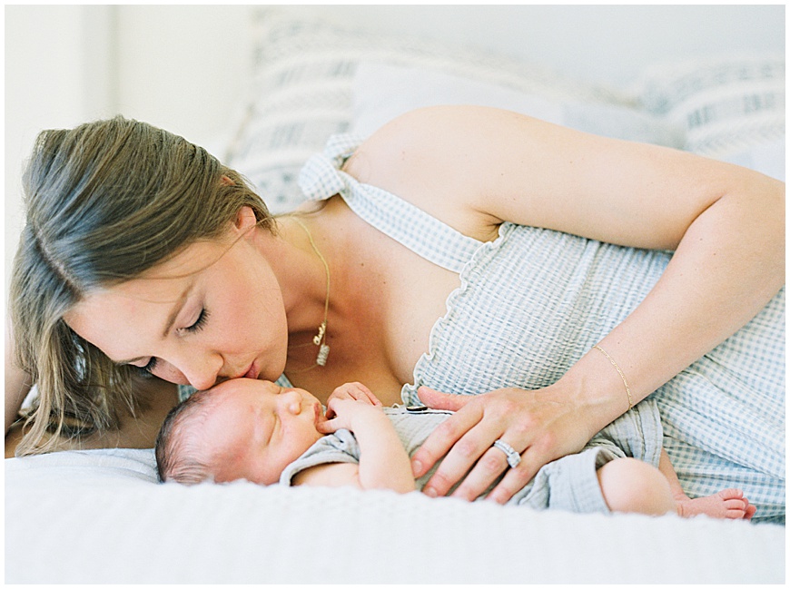 Mother and baby on bed during newborn session.