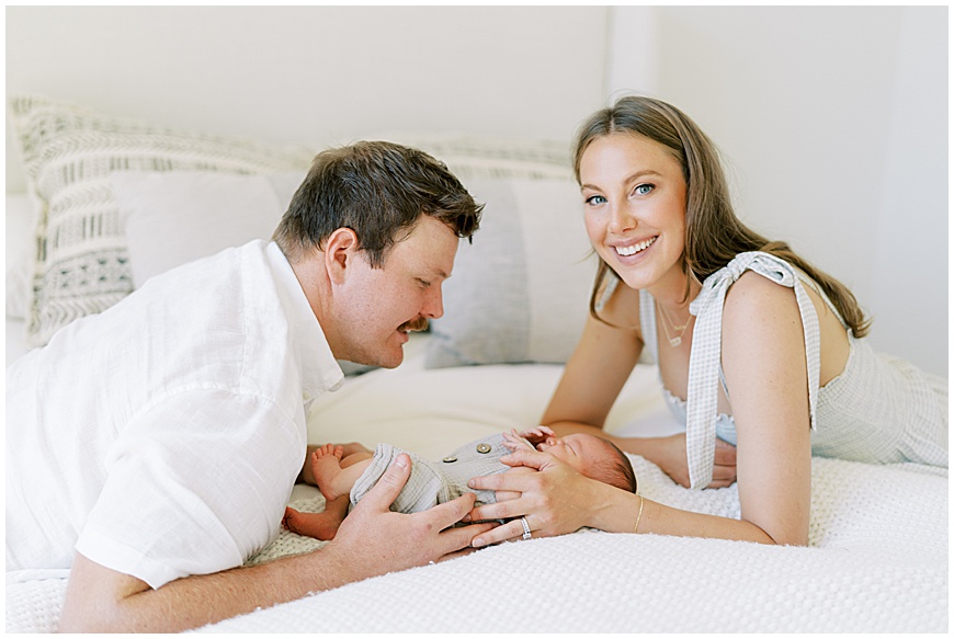 newborn baby, mother and father on bed during newborn session