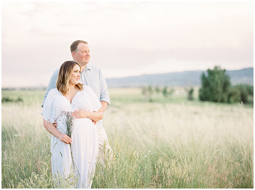 mother and father in field during maternity session