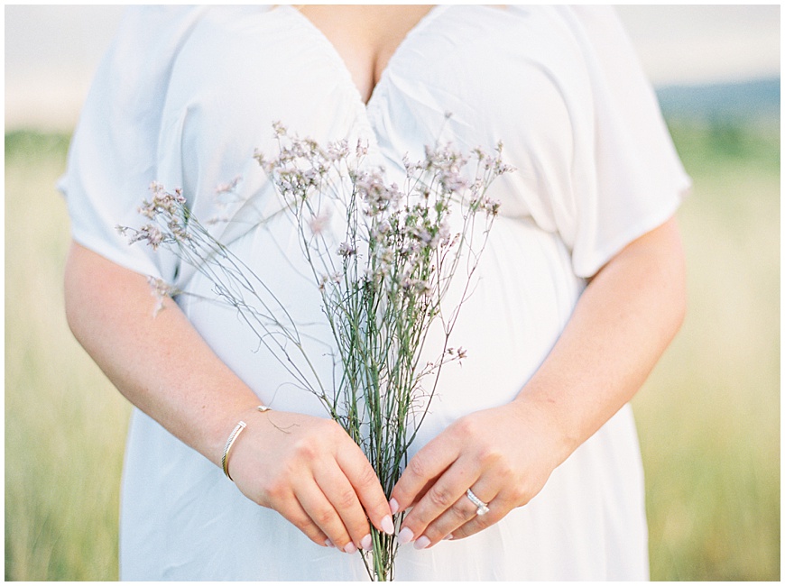 mother holding flowers during maternity session