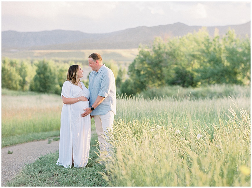 mother and father in field during maternity session