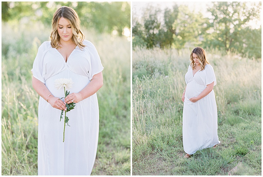 pregnant mother holding flowers in front of mountains in field during maternity session